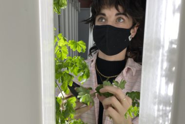 URSU Food Security Coordinator Cassidy Daskalchuk inspects herbs grown by the URSU Hydroponics Project.